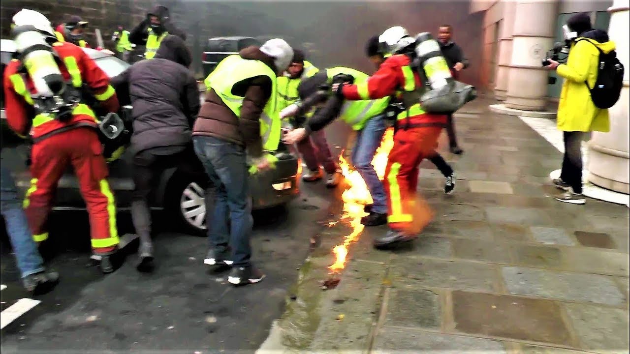 Des Gilets jaunes et des pompiers sauvent de justesse une voiture des flammes - Paris - 1 déc. 2018