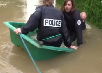 Inondations : Des policiers progressant dans un quartier tombent à l&rsquo;eau depuis leur barque